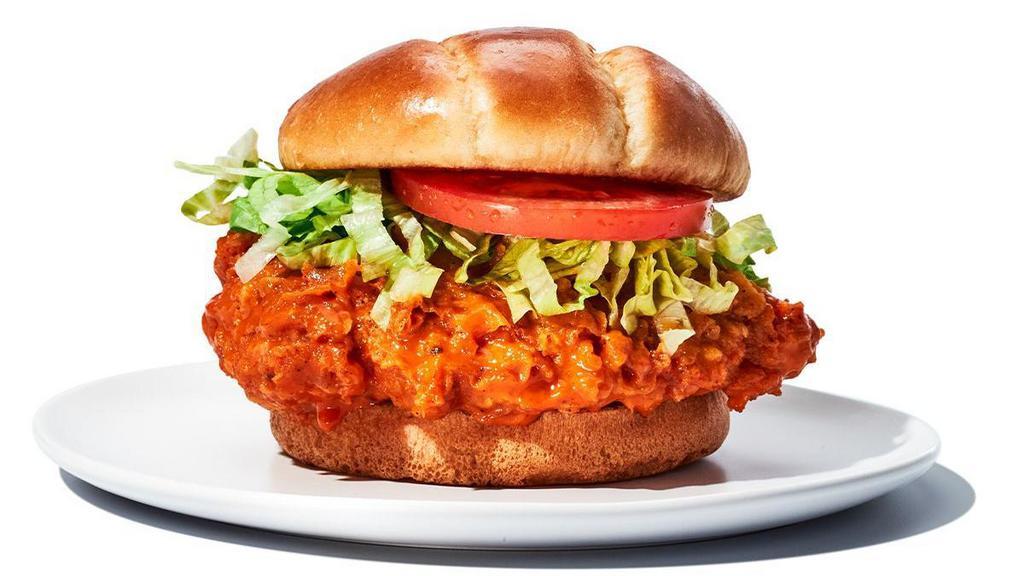 Buffalo Chicken Sandwich · Everything you love about our wings, but in a sandwich. Hand-breaded chicken breast tossed in your favorite wing sauce, topped with lettuce and tomato and served on a toasted brioche bun. Served with fries.  Grilled 590-970 cal | Fried 700-1080 cal