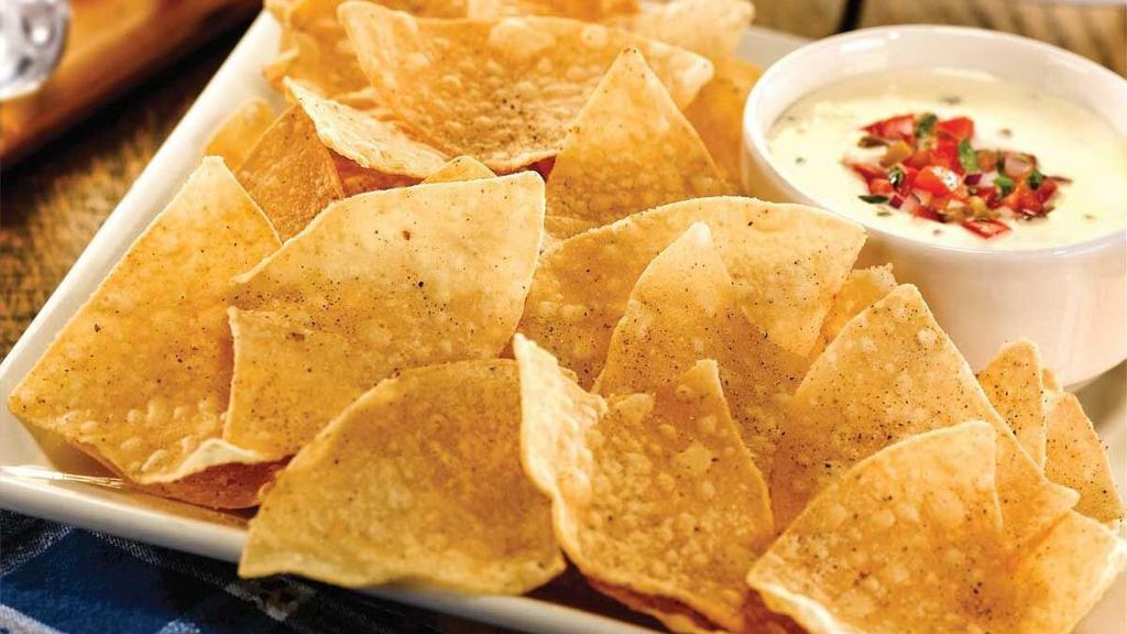 Chips & Queso · Tortilla chips served with our spicy white queso.