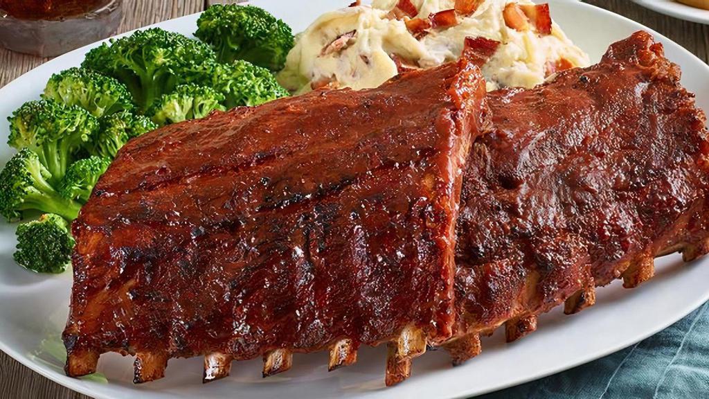 Baby Back Ribs ~ Half Or Full · Our ribs are huge (Full-Rack is pictured)! Rubbed with a blend of brown sugar, paprika, garlic, salt and pepper, then coated with our signature BBQ sauce and slow-cooked until they fall off the bone. Also available with Carolina Gold BBQ sauce or Nashville Hot sauce. Served with two sides.