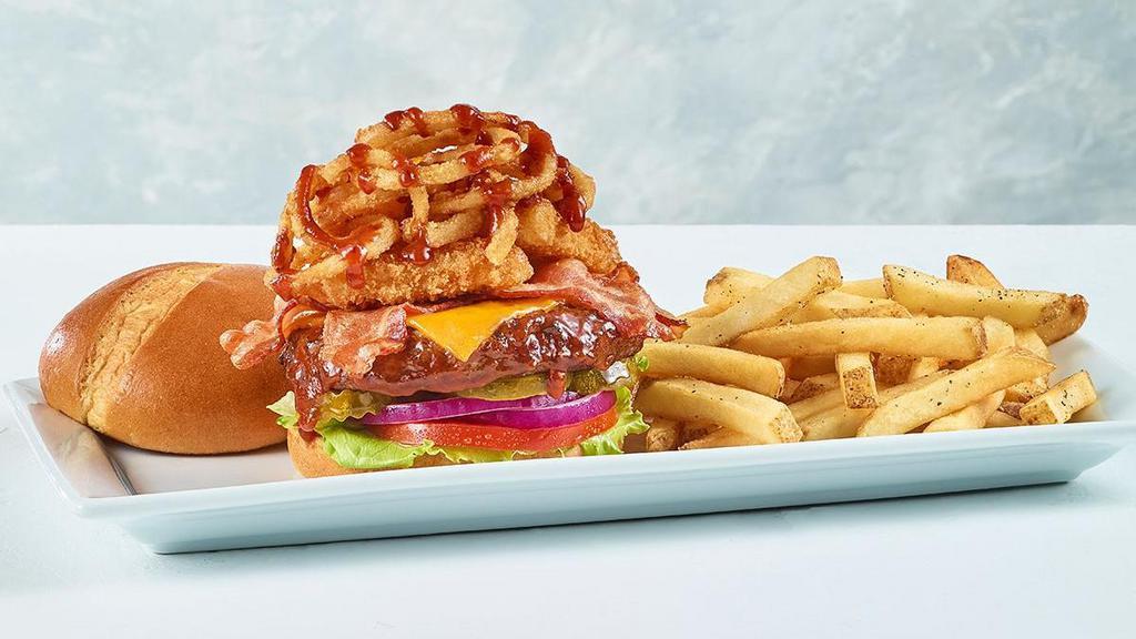 Western Cheeseburger* · Our new knife and fork burger is topped with our signature BBQ sauce, crisp bacon, cheddar cheese. Spicy Jack Cheese Wedges and fried onions. Served on a toasted bun with lettuce, tomato, onion, pickles and a side of fries.