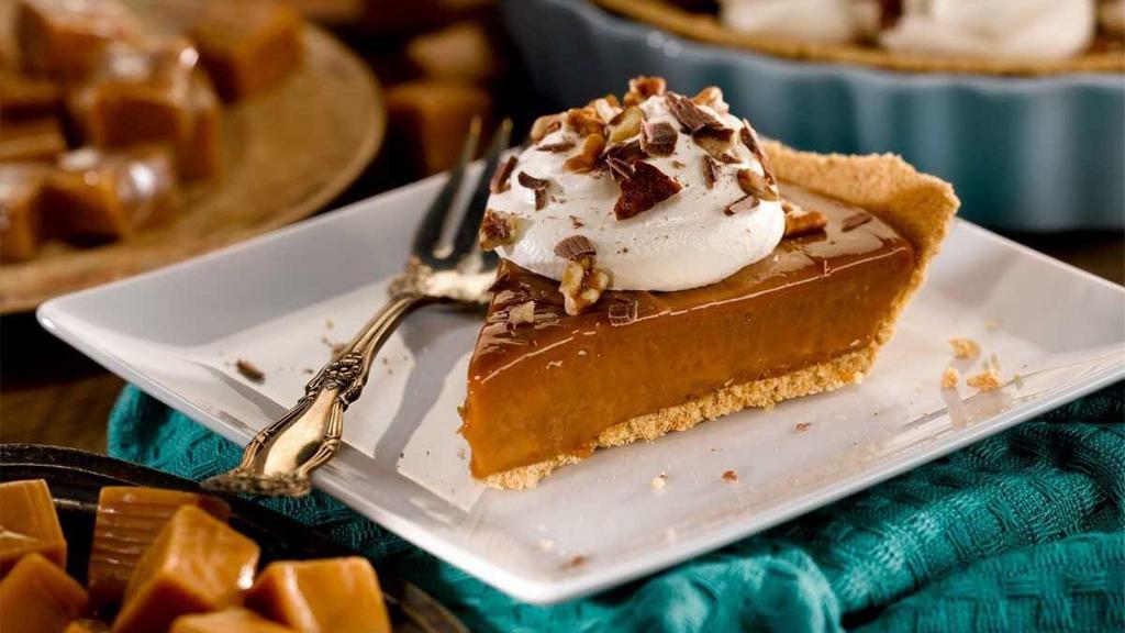 Ooey Gooey Caramel Pie - Slice · Creamy caramel in a graham cracker crust topped with whipped cream, chocolate morsels and pecans.