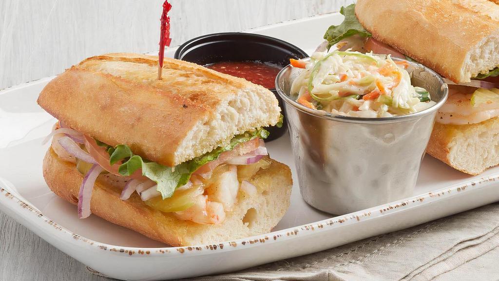 Shrimp Po'Boy (P) · Seasoned shrimp, olive oil, lettuce, tomatoes, pickles, red onions on Parisian bread, with a side of cocktail sauce.