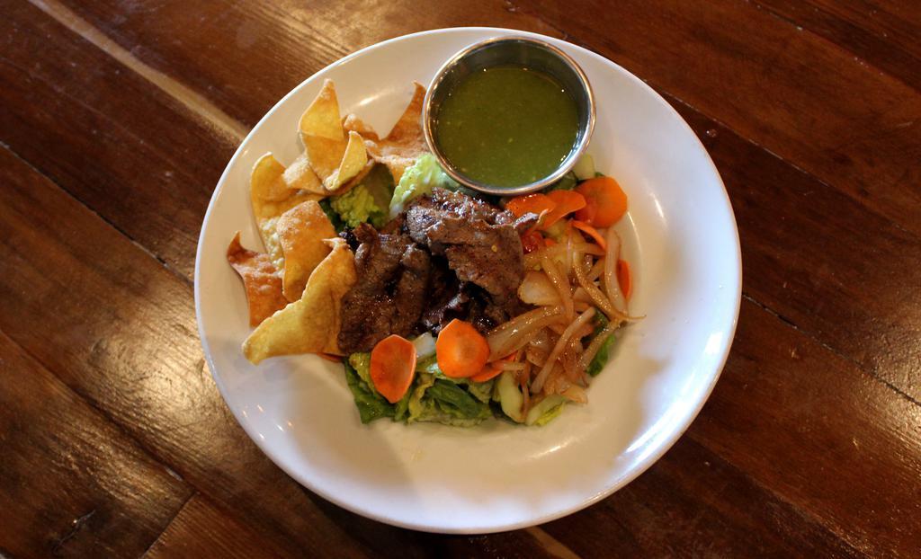 Thai Beef Salad · Grilled flank steak on top of crispy romaine lettuce, sauteed onions, tomatoes, cucumbers, carrots, and wonton crisps, served with green chili dressing