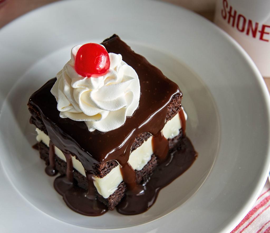 Shoney'S World Famous Hot Fudge Cake · Vanilla ice cream between freshly baked layers of Shoney's famous chocolate cake covered in hot fudge sauce, whipped topping, and a cherry.