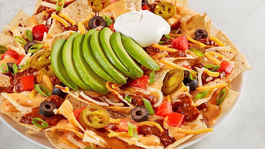 Ultimate Nachos · Chili, RO*TEL cheese sauce, cheddar-jack, tomato, black olives, jalapeños, green onion, avocado and sour cream on tortilla chips.