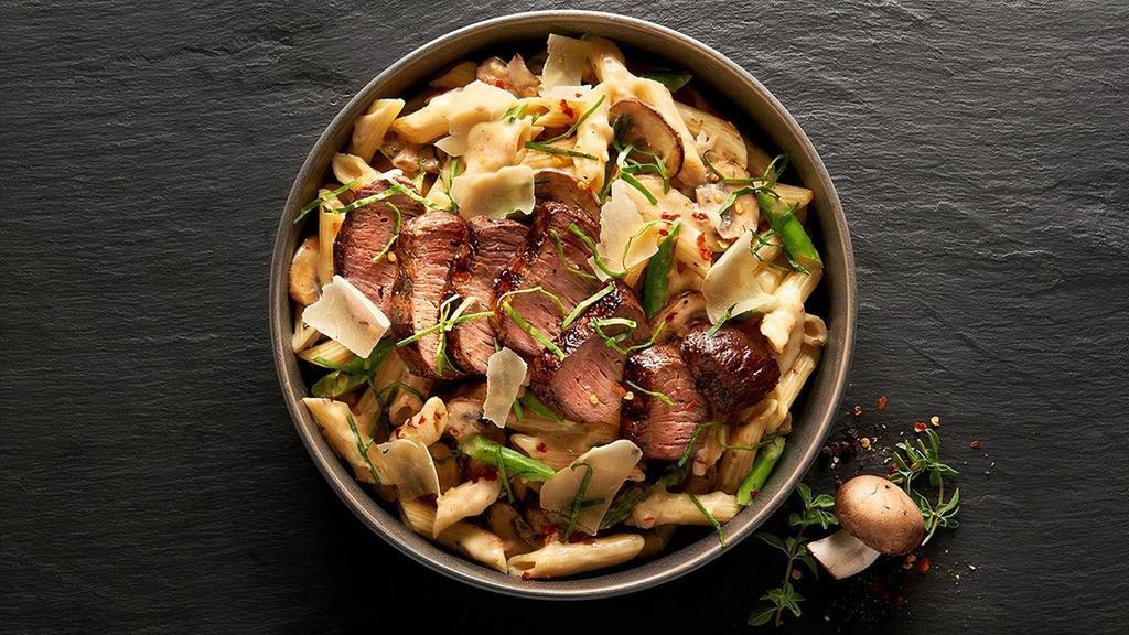 Mandrino'S Garlic Steak Pasta · Tender slices of sirloin steak served over Mandrino's Sun-Dried Tomato Alfredo sauce, chopped asparagus, sliced mushrooms, fresh garlic and tasty penne. Sprinkled with shaved parmesan cheese, fresh basil and red pepper flakes.