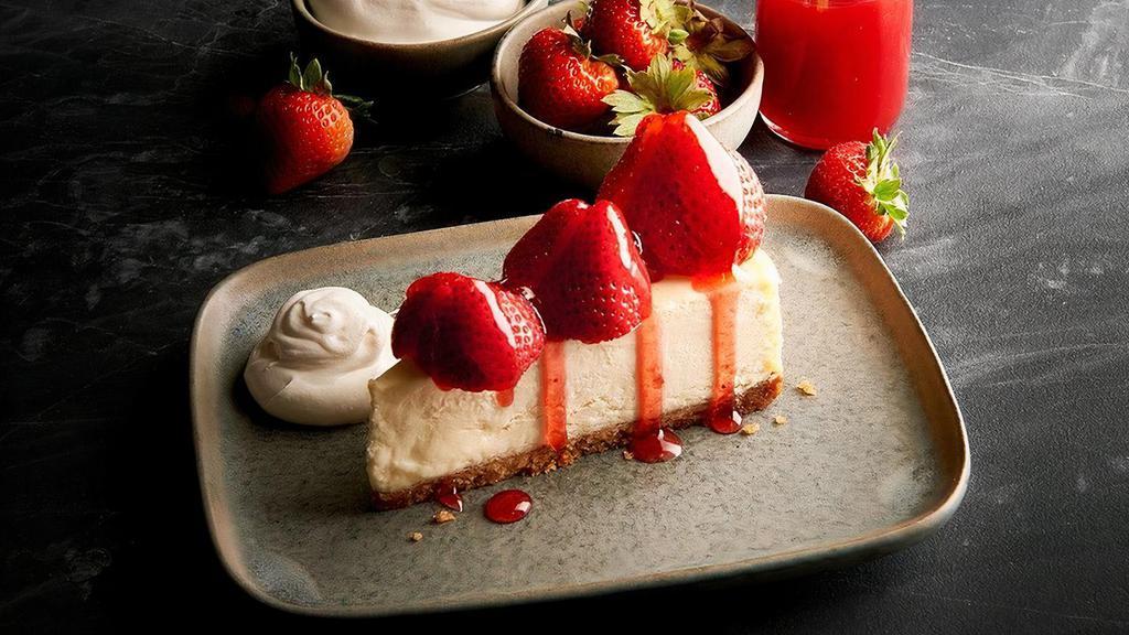 Strawberry Cheesecake · Creamy, New York style cheesecake adorned with fresh strawberries and a strawberry sauce. Served with a dollop of whipped cream.