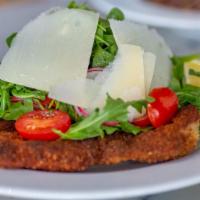 Milanese · Pork chop milanese served with arugula, tomatoes and shaved Parmigiano Reggiano