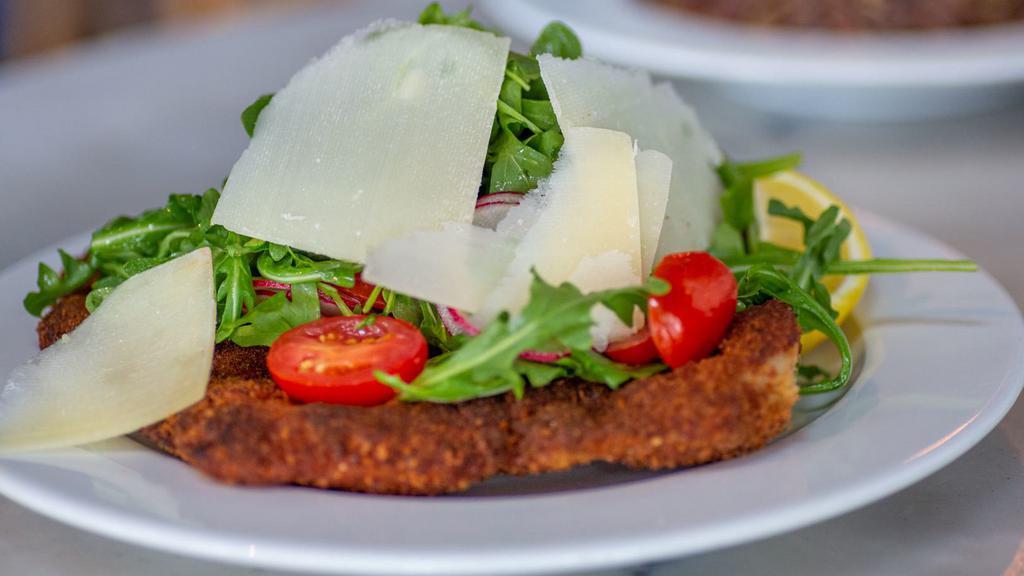 Milanese · Pork chop milanese served with arugula, tomatoes and shaved Parmigiano Reggiano