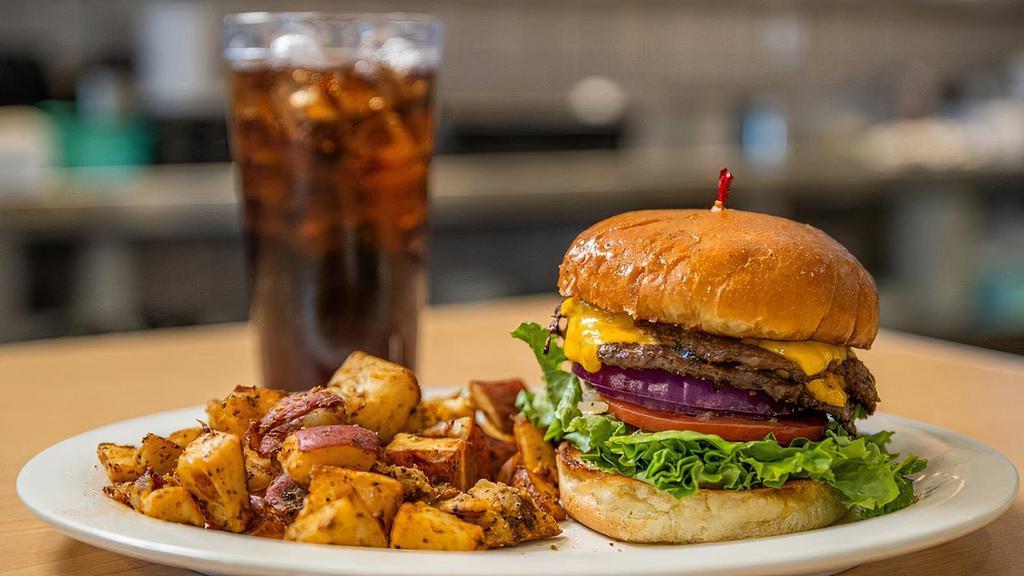 Great American Cheese Burger · A steak burger with American cheese, lettuce, tomato, red onions, mustard, ketchup and dill pickles on a grilled brioche bun.