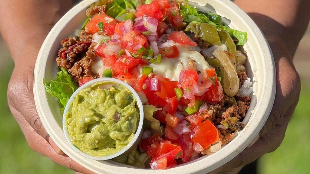 Smoky Impossible Bowl · A base of cilantro lime rice and chopped romaine topped with a marinated Impossible crumble, grilled peppers and onions, melted mozzarella, fresh salsa, and house guacamole.