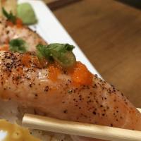 Salmon Belly Nigiri · Torched salmon belly nigiri topped with scallions, sesame seeds, truffle oil and massago.