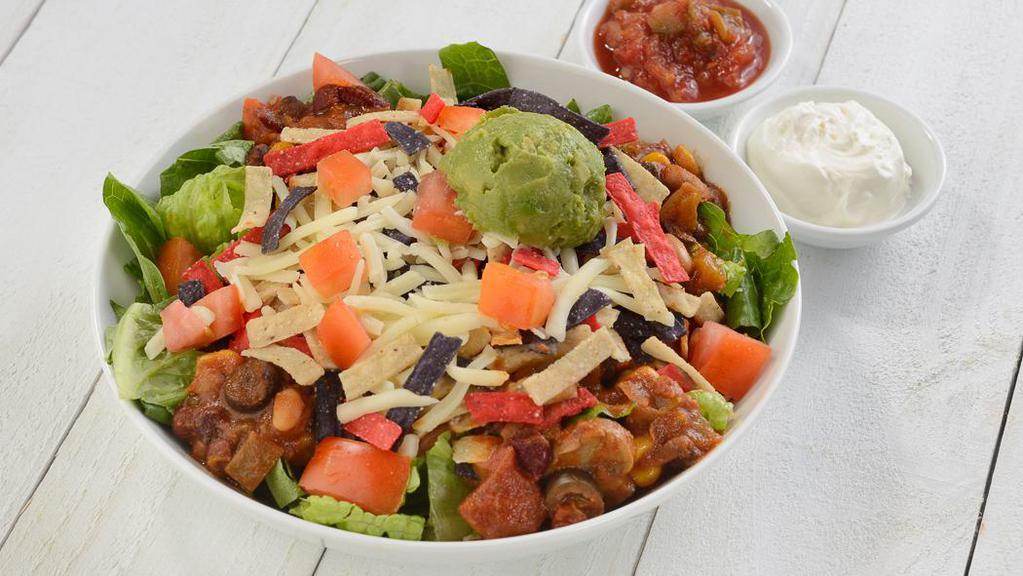 Taco Salad · Vegetarian chili, romaine, tomato, avocado, Cheddar, sour cream, salsa with tortilla strips. Vegetarian and gluten-free.