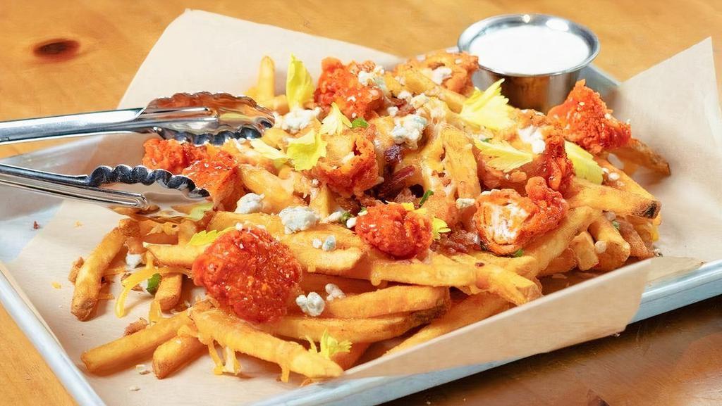 Loaded Fries - Crispy Buffalo Chicken · piled high seasoned fries · buffalo chicken tenders · cheddar · pepper jack · bacon bits · green onions · blue cheese crumbles · celery leaves · bacon ranch