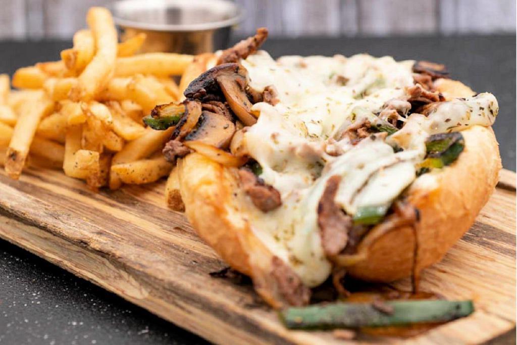 Philly Cheesesteak · thin sliced sirloin · provolone · peppers · caramelized onions · mushrooms · Italian seasoning · mayo · toasted hoagie roll · served with seasoned French fries