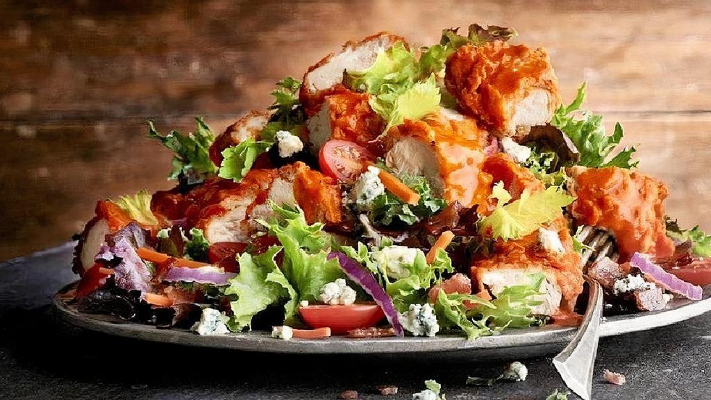 Crispy Buffalo Chicken · crispy buffalo chicken tenders · mixed greens · bacon · red onions · tomatoes · celery leaves · carrots · blue cheese crumbles · bacon ranch