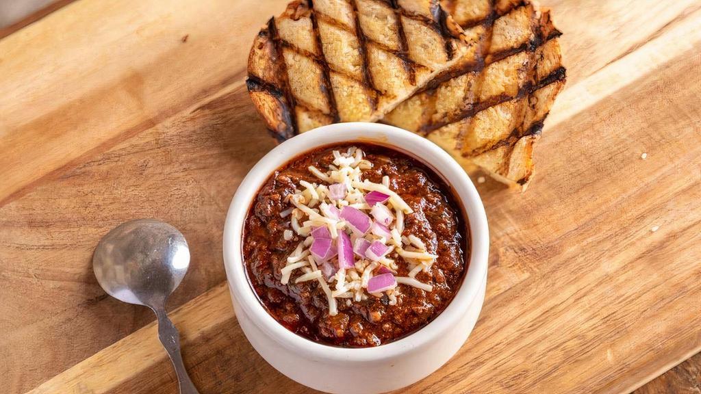Brisket Chili · topped with pepper jack & red onions · served with a slice of grilled sourdough