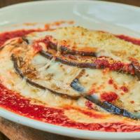 Eggplant Parmigiana · Thinly sliced eggplant with layered mozzarella, parmigiana, basil and tomato sauce.