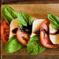 Caprese Salad · Tomatoes, fresh mozzarella and basil topped with a balsamic glaze dressing.