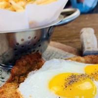 Milanesa A Caballo · Veal milanese topped with two eggs and side of french fries.