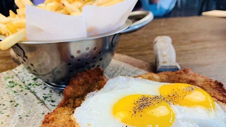 Milanesa A Caballo · Veal milanese topped with two eggs and side of french fries.
