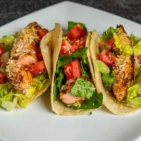 Salmon Tacos · Blackened salmon seared served in a flour tortilla with a chipotle garlic aioli sauce, tomat...
