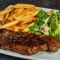12 Oz Ribeye Steak · A 12 oz USDA prime ribeye steak seared and served with a side salad and a baked potato.