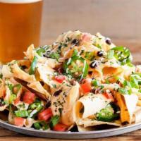 Beer Cheese Nachos · Corn tortilla chips smothered in our Amber Ale beer cheese, black beans, tomatoes, green oni...