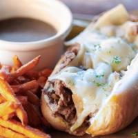 French Dip · Shaved ribeye seasoned and seared, caramelized onions, swiss cheese, garlic aioli, on a ligh...