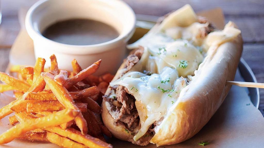 French Dip · Shaved ribeye seasoned and seared, caramelized onions, swiss cheese, garlic aioli, on a lightly toasted hoagie. Served with porter infused au jus.