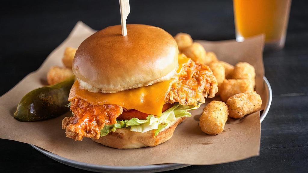 Crispy Buffalo Chicken Sandwich · Lightly hand-breaded beer-brined chicken breast tossed in spicy buffalo sauce & topped with melted cheddar cheese, lettuce and tomato. Served on a toasty brioche bun.