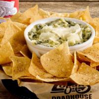 Spinach & Artichoke Dip · A warm, creamy blend of spinach, artichokes, Swiss and Parmesan cheeses, served with tortill...