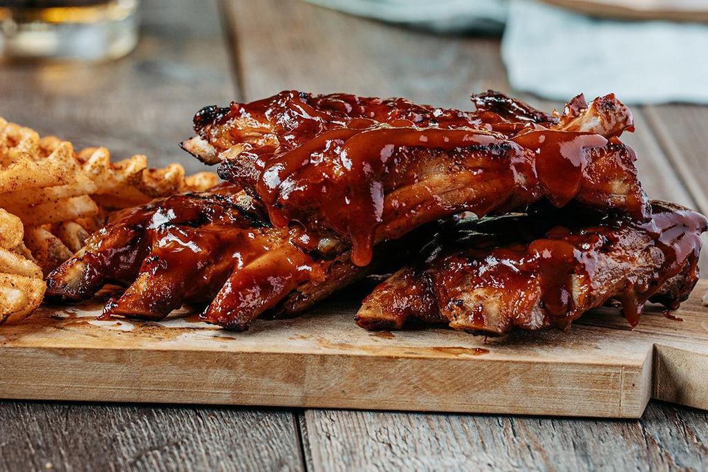 Full Stack Of Fall-Off-The-Bone Ribs · Slow-cooked in-house for maximum flavor.