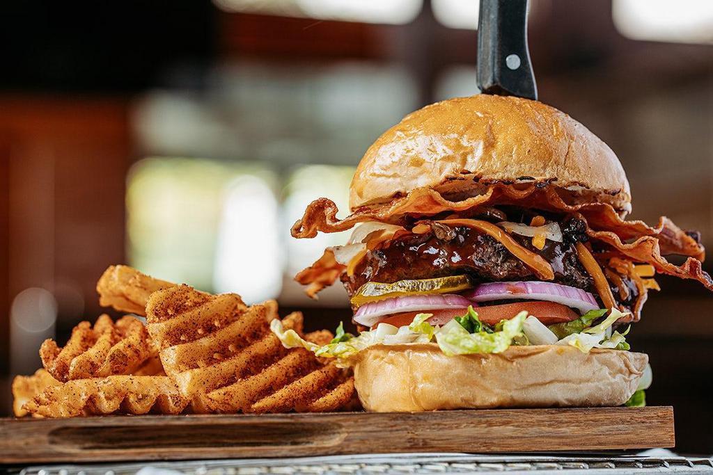 Roadhouse Deluxe* · Served with thick-cut hardwood smoked bacon, signature Roadhouse BBQ sauce, shredded cheddar cheese, Brewski Onions® and sautéed mushrooms.