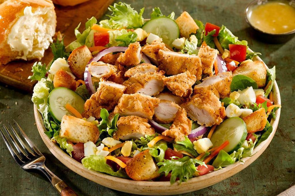 Fried Chicken Salad · Crispy, hand-breaded chicken tenders served over mixed greens, tomatoes, cheddar cheese, red onions, cucumbers, hard-boiled egg and croutons.