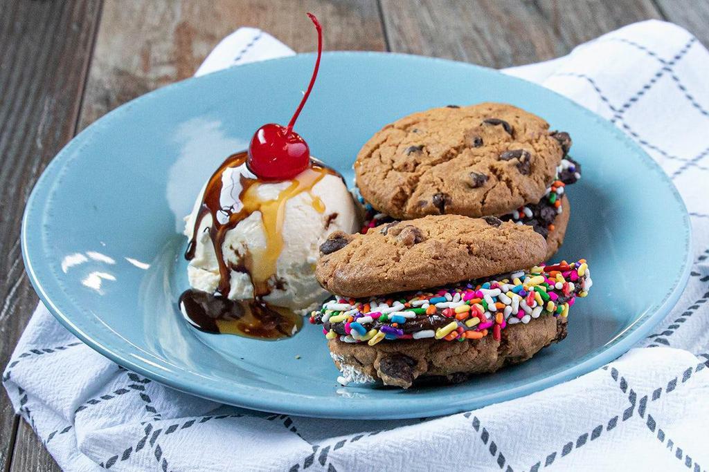 Cookie Slider Sundae · 2 Cookie Sliders - Fudge Brownie coated in sprinkles, sandwiched between fresh-baked chocolate chip cookies, served with ice cream and topped with chocolate and caramel sauce. (contains nuts)