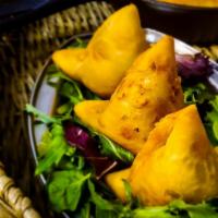 Veggie Samosa · Traditional Punjabi style fried pastry stuffed with spiced potatoes and peas. Served with mi...