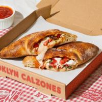 The L Train Calzone · Calzone with parmesan cheese, melted mozzarella, tomato, basil, and a side of marinara.
