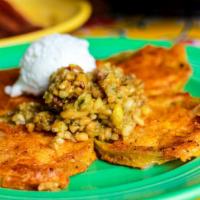Oven Fried Green Tomatoes · Dredged in seasoned cornmeal, topped with cashew-jalapeño relish and goat cheese.
