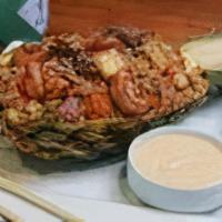Pineapple Fried Rice · Combination of chicken, steak, & shrimp sauteed with pineapple chunks. Served on a half pine...