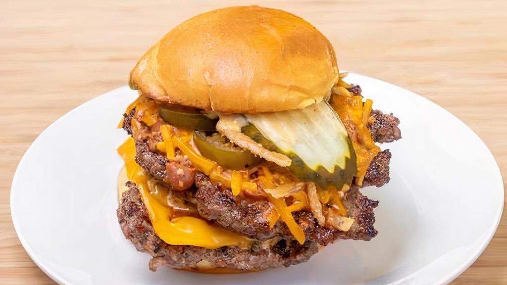 The Big Texas Burger · The BIG Texas Burger features double Certified Angus Beef, American & Cheddar cheese, Texas-style chili, charred jalapenos, crispy fried onions, house sauce, and pickles. Lettuce & tomato on request.