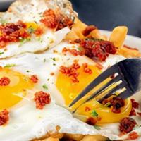 Huevos Estrellados · Three broken sunny side up eggs on French fries +ground chorizo