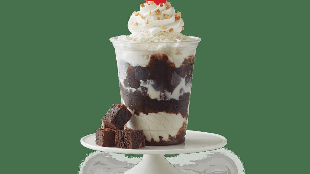Fudge Brownie Sundae · Vanilla Ice Cream with fudge brownie pieces and fudge, topped with whipped cream, chopped peanuts, and a cherry.