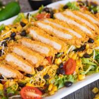 Southwest Chicken Salad · House greens topped with shredded Colby-Jack cheese, cherry tomatoes, roasted corn, black be...