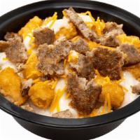 Country Gravy Grits · Bowl of made-from-scratch grits loaded with tater tots, country gravy, cheddar & sausage
