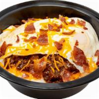 Chili Cheddar Grits · Bowl of made-from-scratch grits loaded with chili, cheddar, over well eggs & bacon