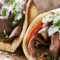 Lamb Gyro · Sliced lamb set on pita bread topped with lettuce, tomatoes, onions and tzatziki sauce serve...
