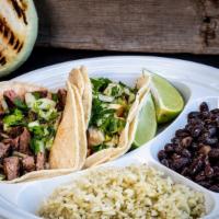 Two Taco Combo Plate · Two tacos on a plate with cilantro rice and beans. Includes chips and salsa.