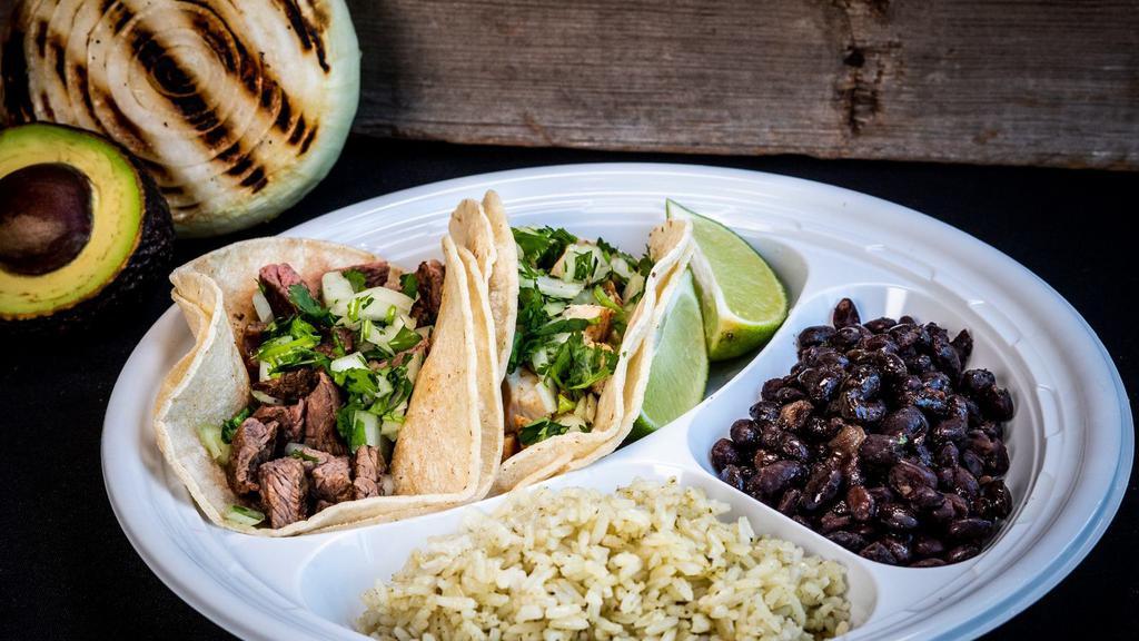 Two Taco Combo Plate · Two tacos on a plate with cilantro rice and beans. Includes chips and salsa.
