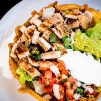 Tostada Salad · Flour tortilla shell stuffed with lettuce, tossed in lemony dressing, beans, guacamole, sour...